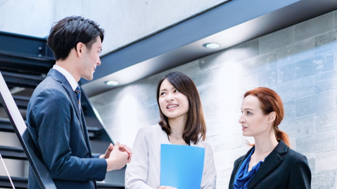 階段で談笑する3人の社員